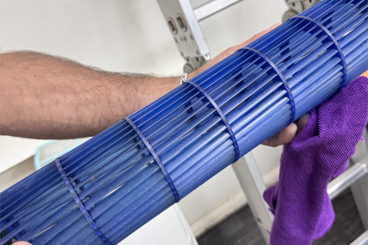 Técnico de Ventoclima limpiando la turbina del aire acondicionado durante la mantención