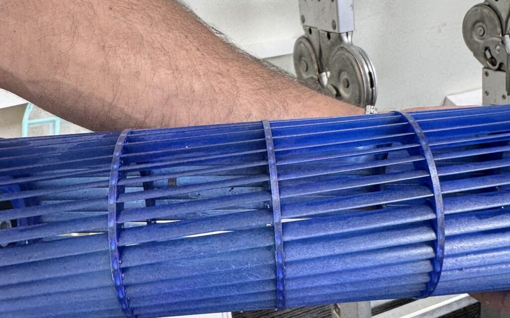 Técnico limpiando la turbina de una unidad interior de aire acondicionado